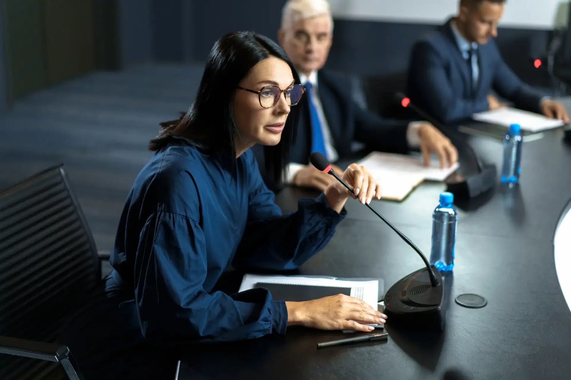 Professional woman speaking at a conference with microphone